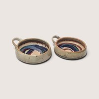 Set of two 1980s handmade stoneware bowls with loop handles and colorful glazed swirl patterns inside.