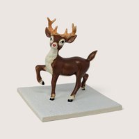 Vintage hand-painted ceramic Rudolph reindeer figurine mounted on a textured white square tile base.
