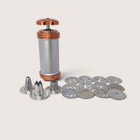 Vintage Mirro aluminum cookie press with copper-tone accents, 12 pattern disks, and 3 icing tips.
