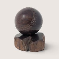 Vintage hand-carved wooden baseball display figurine resting on a natural wood base.