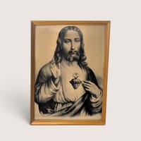 Vintage sepia tone framed print of the Sacred Heart of Jesus in a wood frame behind glass.