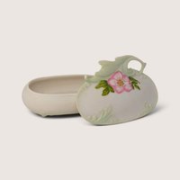 Vintage ceramic trinket box with a sculpted lid featuring a hand-painted pink flower and pastel green accents, shown open with lid resting beside it.