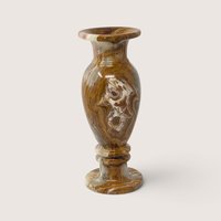 A vintage turned alabaster stone vase featuring rich brown and cream banded marbling patterns with a flared rim and stepped pedestal base against a neutral background