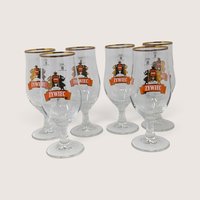 A set of six vintage Ritzenhoff Cristal Zywiec stemmed beer glasses with gold rims and folkloric graphics, displayed with their original packaging box.