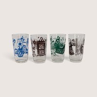 A set of four vintage clear juice glasses featuring different multi-colored screen-printed domestic scenes including a grandfather clock and household objects.
