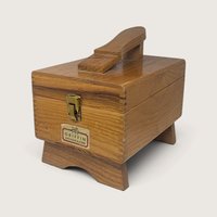 A vintage wooden Griffin Shinemaster shoe shine box with a built-in footrest on top, a brass latch, and a maker's label on the front.