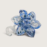 A vintage blue and white art glass flower figurine with speckled details, a wide blossomed head, and a clear looped stem base.