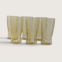 A set of six vintage amber depression glass tumblers featuring the Federal Glass Madrid scroll pattern on a neutral background.