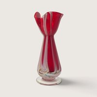 Vintage hand blown ruby red art glass bud vase with white pulled feather swirls and clear foot on white backdrop.   