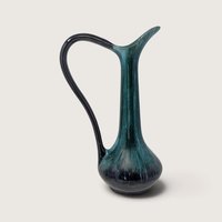 Vintage Blue Mountain Pottery tall ceramic pitcher vase with flowing emerald green and black drip glaze on white backdrop.   