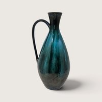 Vintage Blue Mountain Pottery tall ceramic teardrop pitcher vase with green and black flowing drip glaze on white backdrop.   