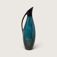 Vintage Blue Mountain Pottery slender ceramic pitcher vase with flowing green and black drip glaze on white backdrop.   
