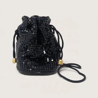Vintage black enameled metal mesh mini drawstring bucket bag with gold bell cord ends on a light backdrop.   