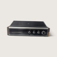 Vintage 1970s Panasonic RE-7441 AM/FM tabletop radio with black top speaker grille, faux woodgrain sides, and chrome dials.   
