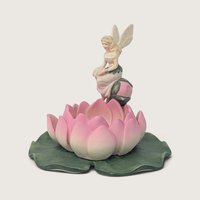 Vintage PartyLite ceramic candle holder featuring a blonde fairy perched on a pink water lily flower and green pad.   