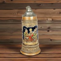 A 10-inch tall ceramic beer stein with a metal lid, featuring a colorful relief scene of three people sitting at a tavern table drinking from mugs.