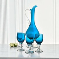 A 12-inch tall bright blue hand-blown glass decanter with a clear twisted handle, standing behind five matching 4.25-inch cordial glasses with clear twisted stems.