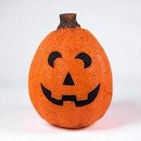 A vibrant orange jack-o'-lantern blow mold with a pebbled, crystalline texture. It features a smiling black face with arched eyes and a triangular nose, topped with a dark, textured stem. The silhouette is an elongated, upright oval.