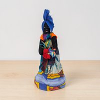 A tall handmade cloth doll with a hand-painted face and yarn hair. The doll has jointed limbs at the shoulders and hips, a slender silhouette, and is wearing a floral patterned dress with a lace-trimmed apron.