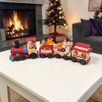 A multi-piece ceramic train set with a high-gloss finish. The texture is smooth glazed pottery featuring a red and green color palette with a horizontal, locomotive silhouette.