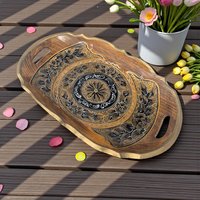 A rectangular shallow wooden tray with a dark finish. The center features handpainted gold and black botanical motifs, including delicate floral scrolls and leaf patterns against the natural wood grain.