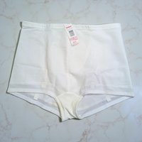 A pair of vintage white high-waisted control briefs with a textured floral pattern on the front panel. The original paper tag is still attached to the waistband.