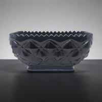 Deep black opaque glass bowl with a relief diamond block pattern across the exterior. Scalloped serrated rim and a rectangular pedestal base. High-gloss finish reflecting light off geometric facets.