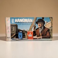 A game box featuring a cinematic photo of actor Vincent Price in a brown coat and black bowler hat. He stands next to a gallows rope with a weathered town in the background. Two plastic game consoles, one blue and one red, are pictured in the foreground.