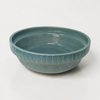 A teal stoneware bowl with an embossed geometric fence and diamond pattern on the exterior. The interior is a smooth, glossy matching teal. The silhouette is a wide, shallow basin with a slightly flared rim.