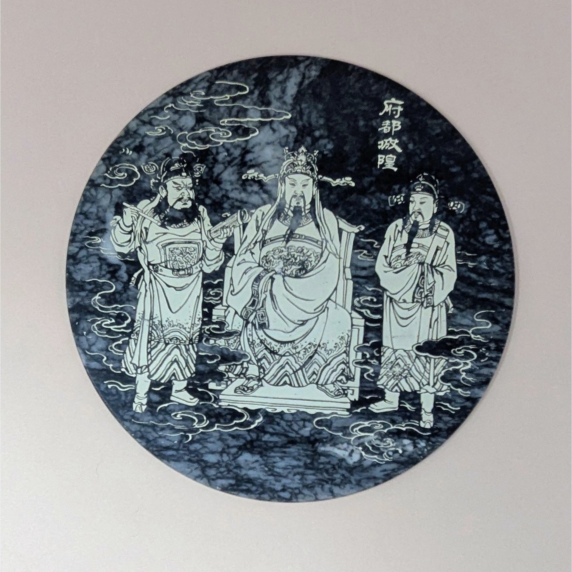 Round black and white veined marble plaque with a detailed white line engraving of three figures in traditional Chinese robes representing the City God (Cheng Huang). 8 inches in diameter.