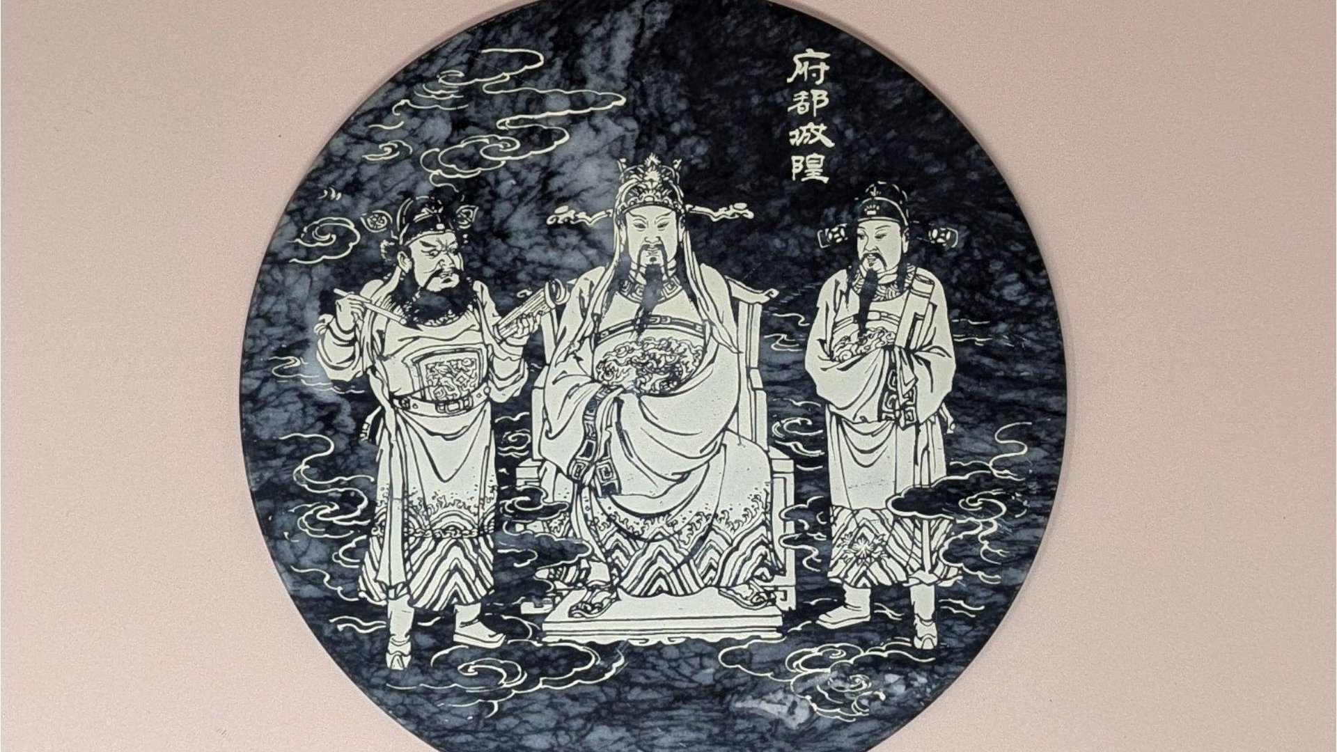 Round black and white veined marble plaque with a detailed white line engraving of three figures in traditional Chinese robes representing the City God (Cheng Huang). 8 inches in diameter.