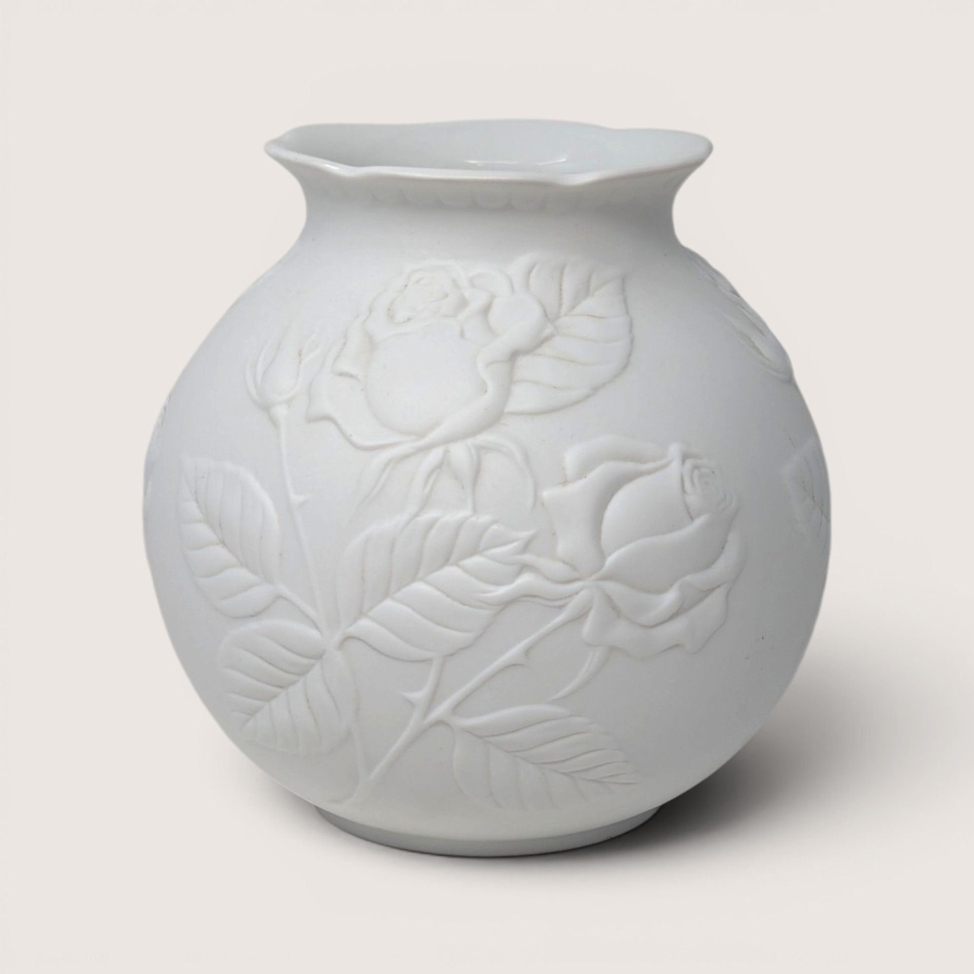 Vintage Kaiser white bisque porcelain vase featuring an embossed rose and foliage relief design.