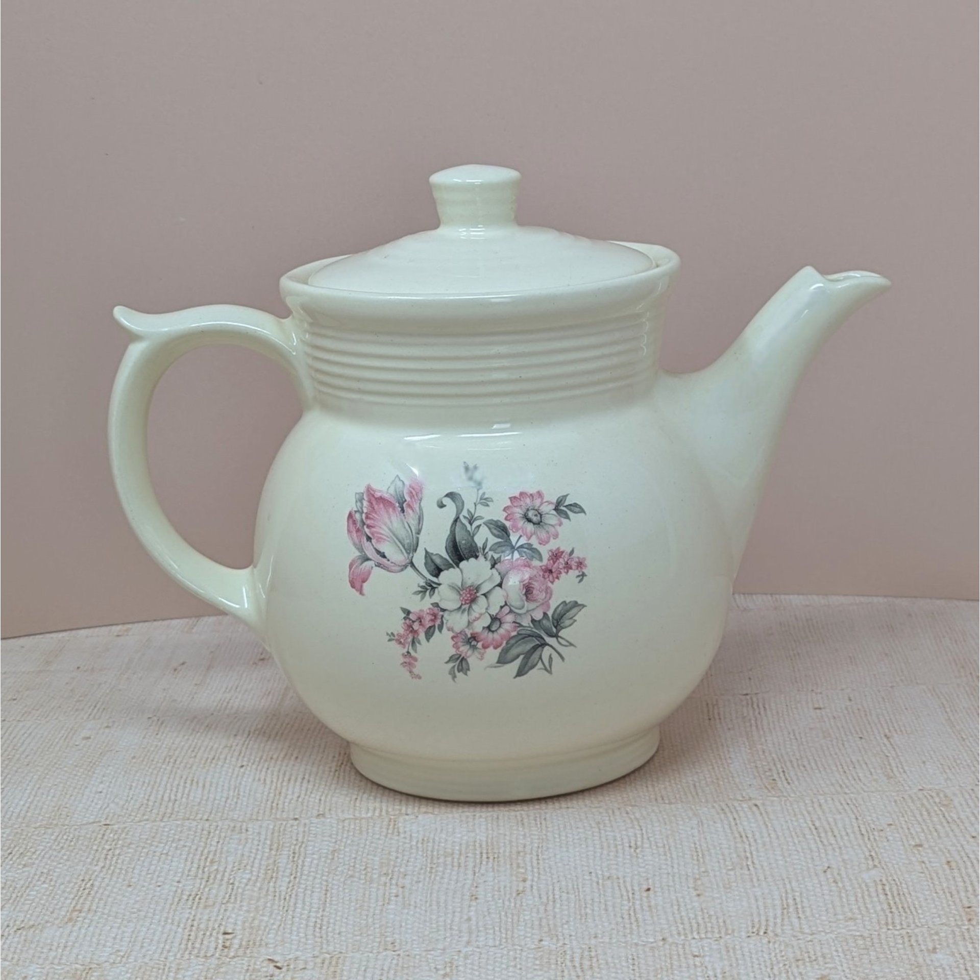Vintage cream ceramic Drip-O-Lator coffee pot and lid. Features a central floral spray of pink tulips and white daisies. Sculptural scroll-top handle and tiered "stepping" on the neck. 7.25 inches tall.