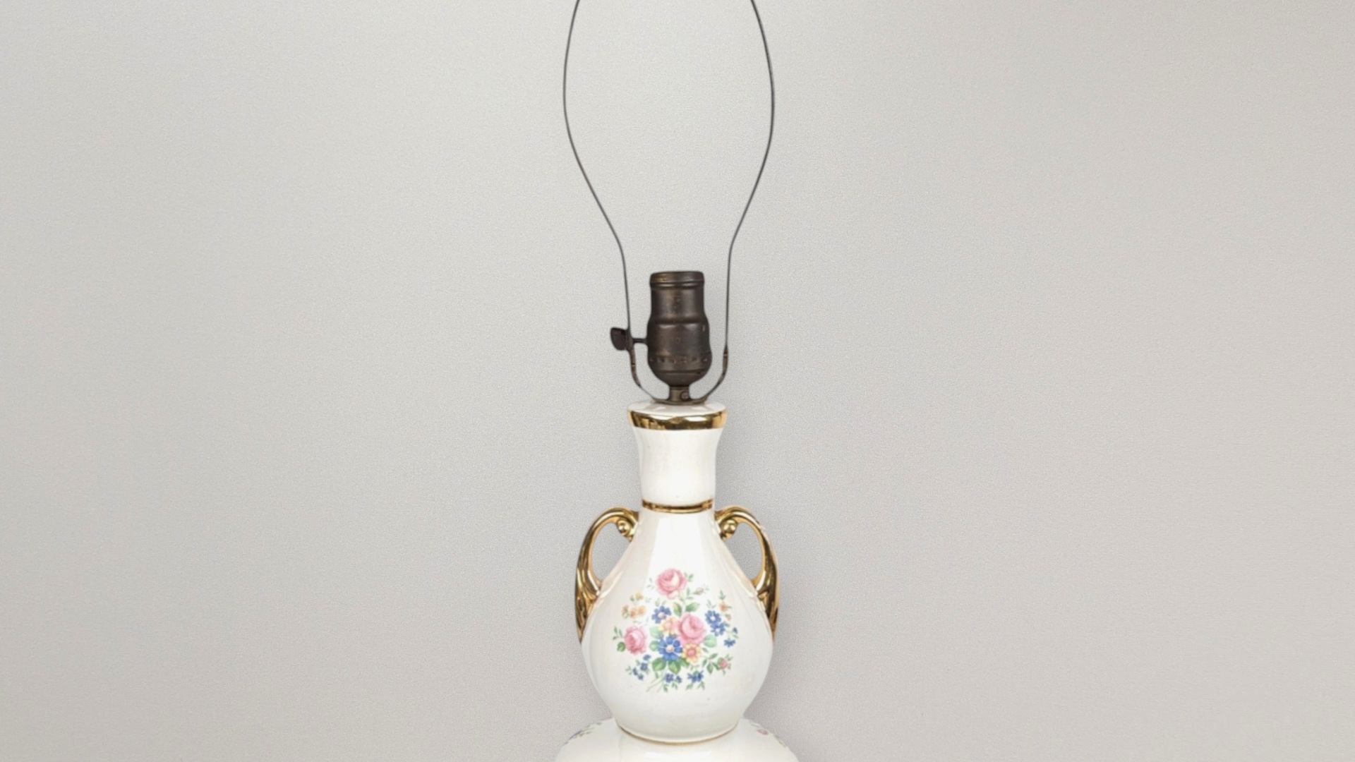 Tall vintage white ceramic table lamp with a double-bulbous silhouette and gold-gilt handles. Features a colorful floral bouquet of pink roses and blue wildflowers. 21.5 inches tall.