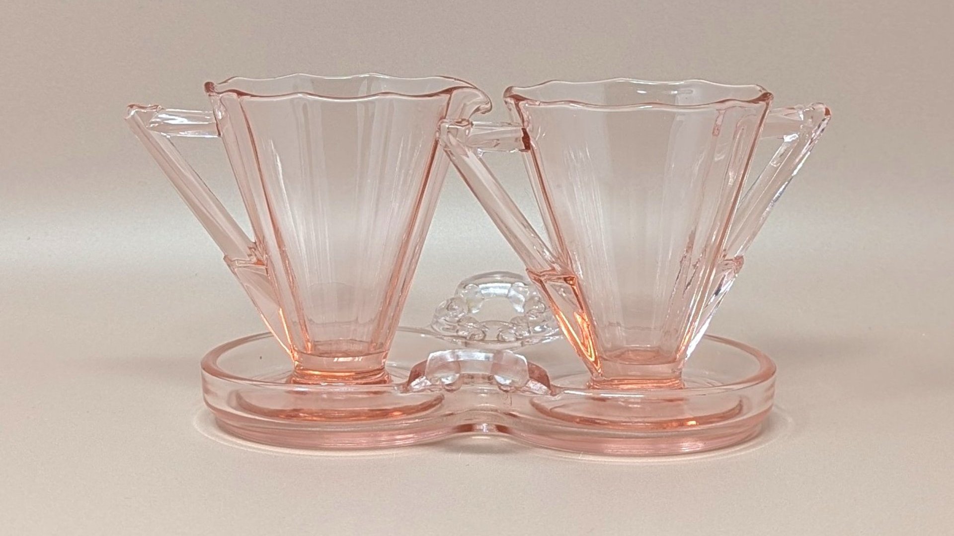 Vintage Cambridge pink glass sugar and creamer set on a matching double-well tray. Features 10-sided decagon panels and sharp geometric handles. 3.5 inches tall.