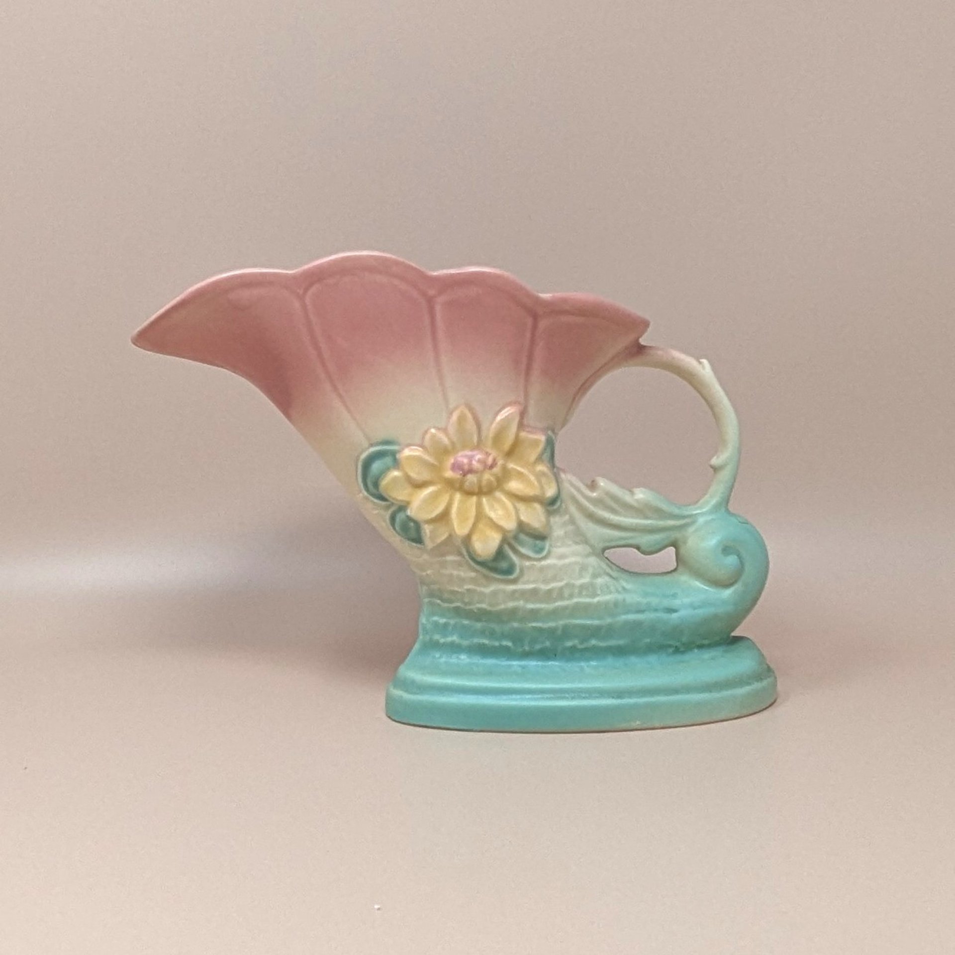 Vintage Hull Art Pottery cornucopia vase in the Waterlily pattern. Features a shaded pink-to-turquoise ombré matte glaze with an embossed yellow waterlily. 6.5 inches tall.