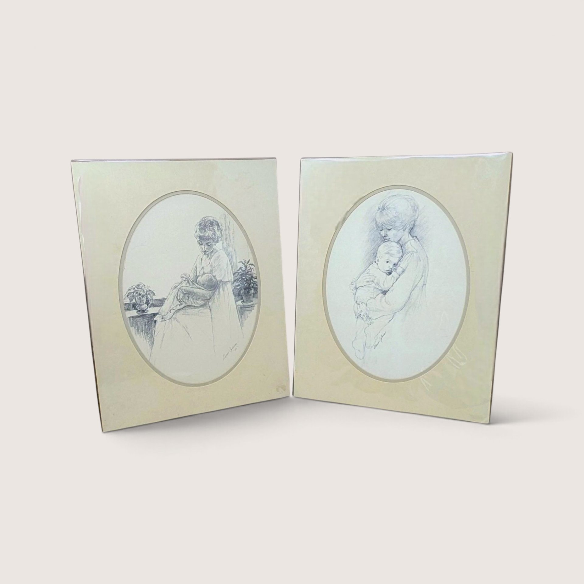 Pair of vintage 1975 Sharon Johnson mother and child pencil sketch art prints in oval mats.