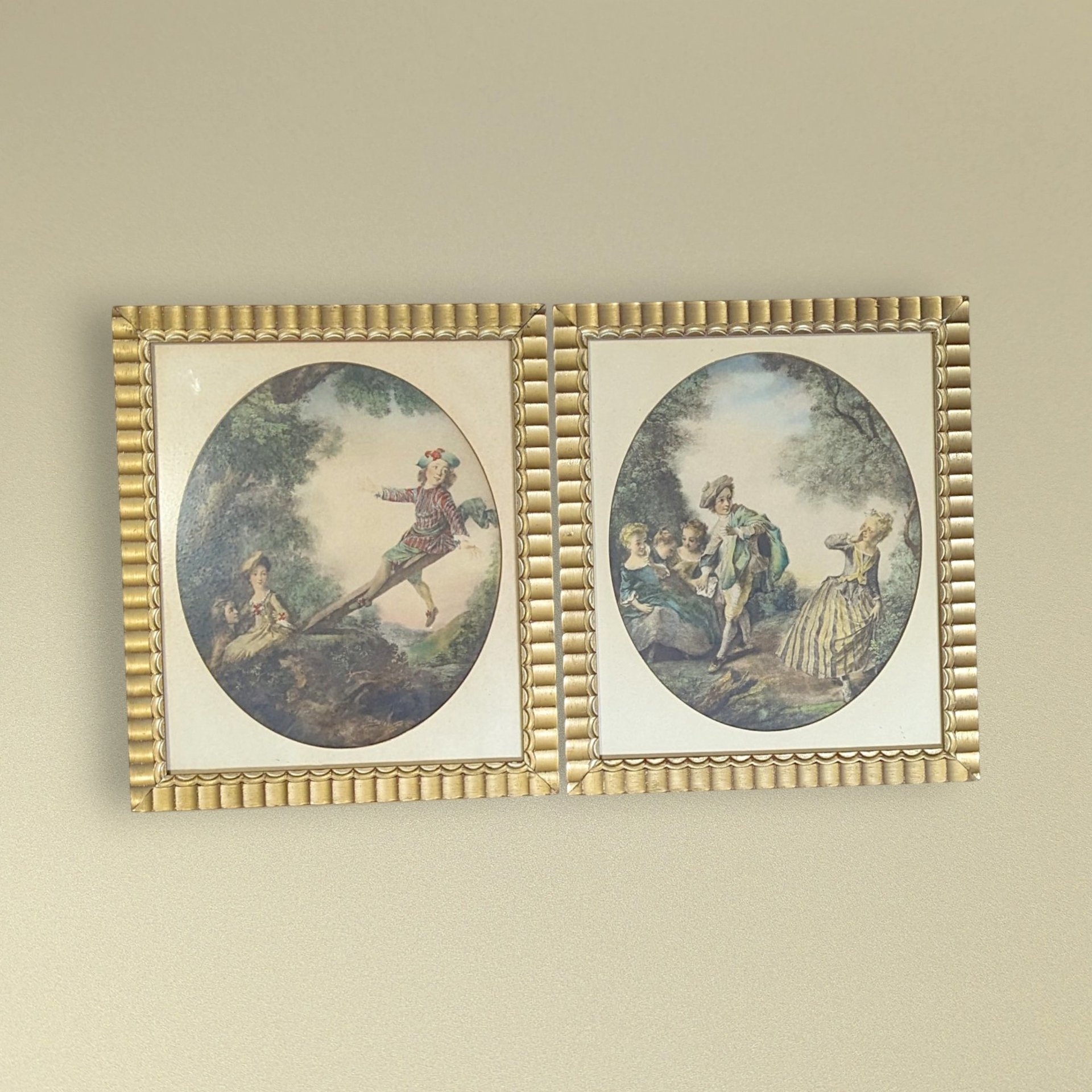 Set of two 1940s framed art prints by Nicolas Lancret titled "The Seesaw" and "Dropping the Handkerchief." Features pastoral Rococo scenes in ornate scalloped gold frames. 14.25 x 12.25 inches.