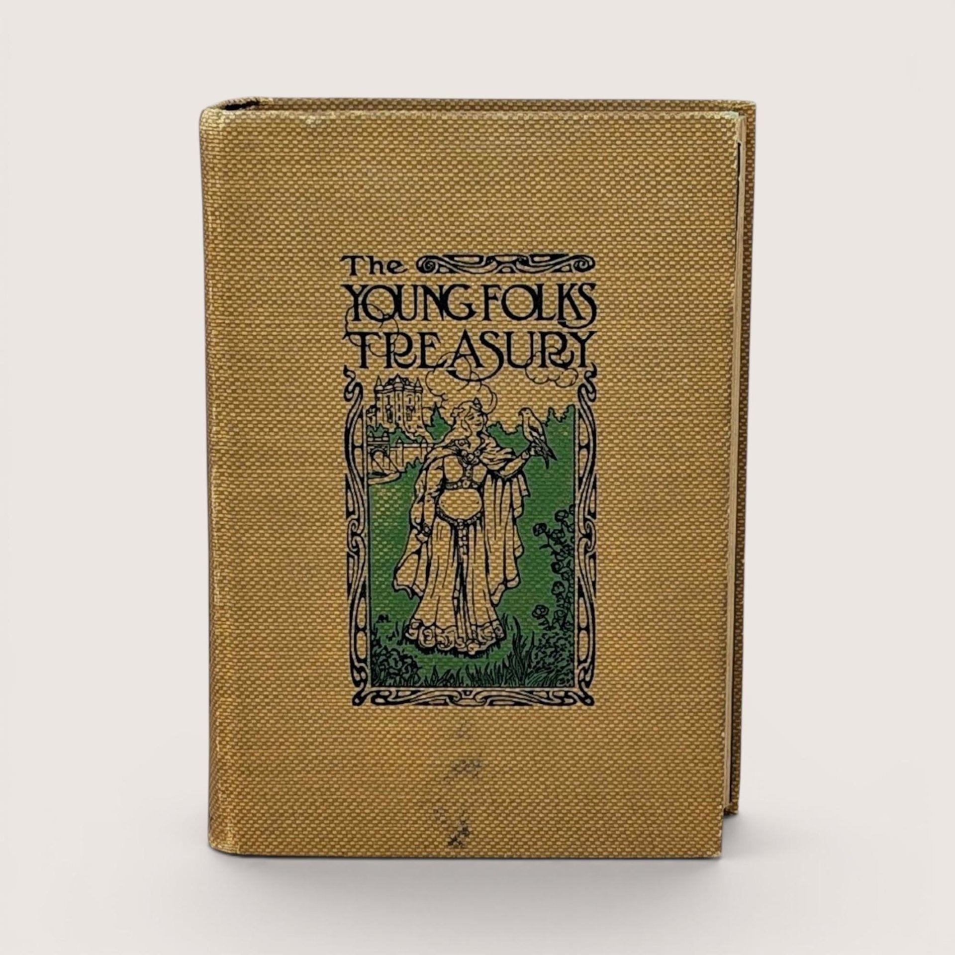 Antique book with a golden-yellow textured cloth cover. Features an Art Nouveau illustration of a woman with a hawk and a castle. Titled "The Young Folks Treasury" in stylized black font. Aged, tactile fabric finish.