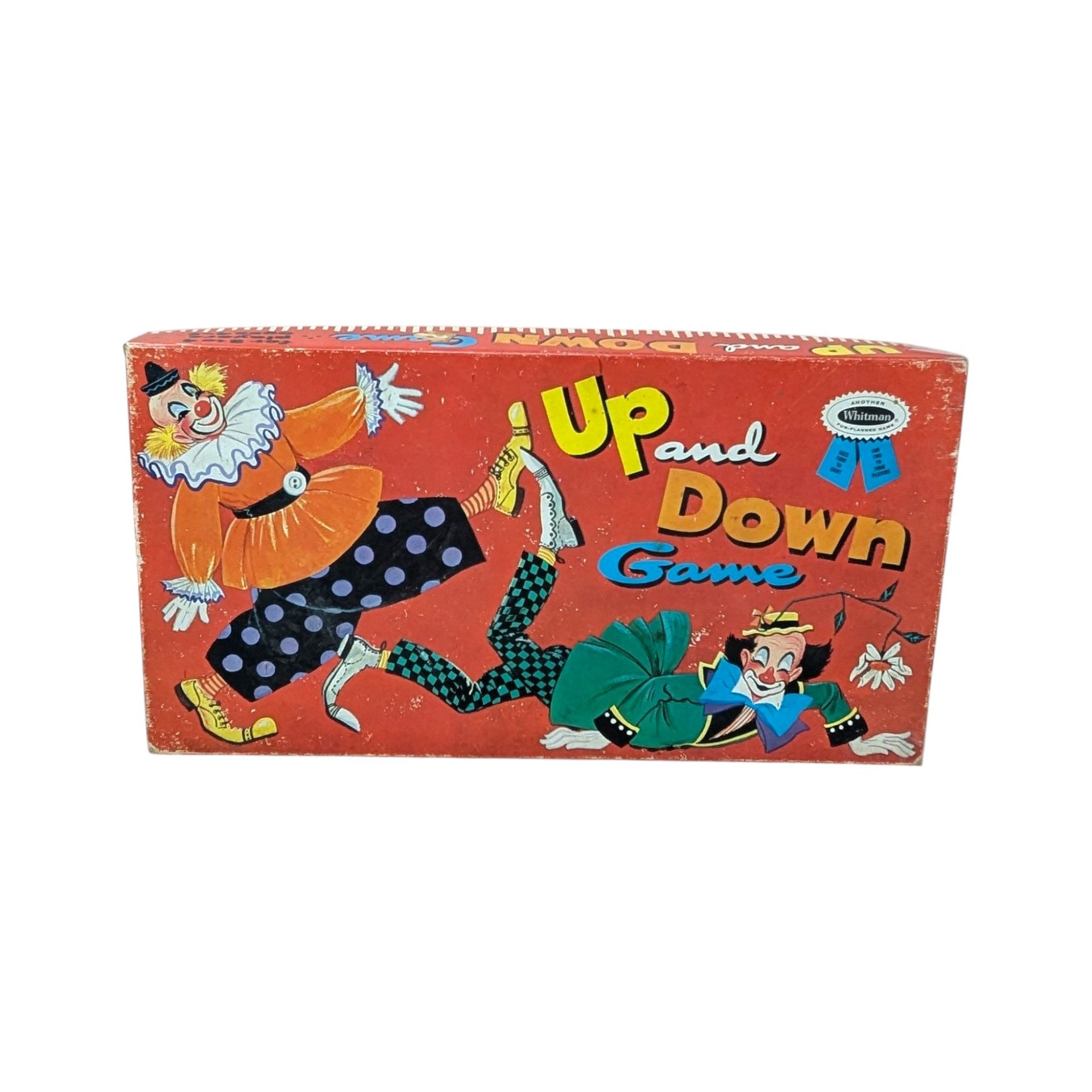 A horizontal vintage board game box for "Up and Down Game" by Whitman. Features two whimsical clowns in colorful costumes against a vibrant red background. Matte paper texture with visible edge wear and aged patina.