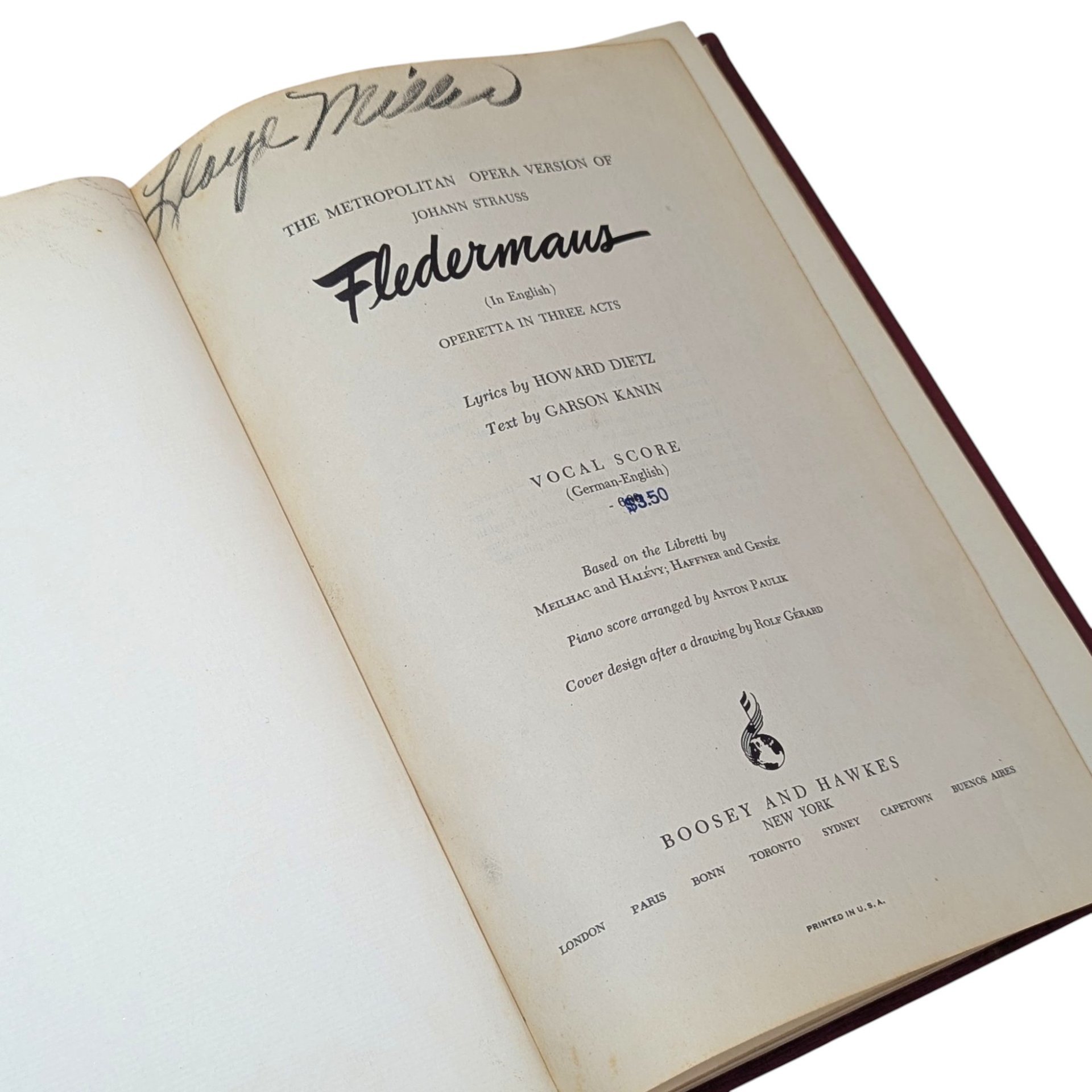 A vintage musical score book titled Fledermaus by Johann Strauss. The title page features elegant black typography and a handwritten signature at the top. The paper shows a warm, aged patina consistent with its mid-century origin.