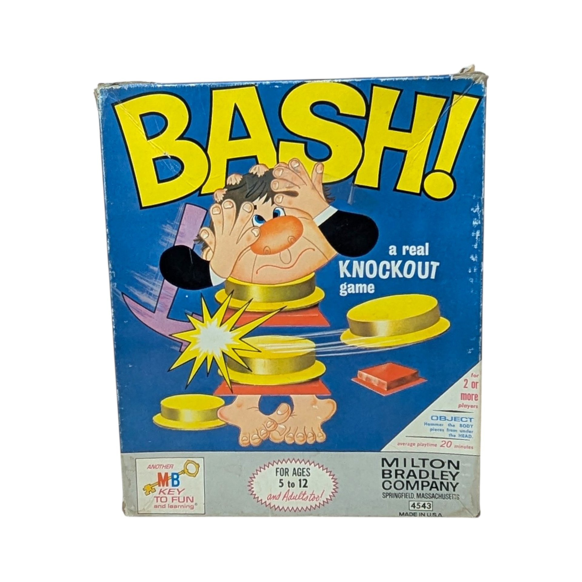 The original 1965 box for the Milton Bradley game "BASH!" featuring a bright blue background and a cartoon man being "bashed" apart. The box shows vintage shelf wear but remains structurally sound with vibrant yellow lettering.