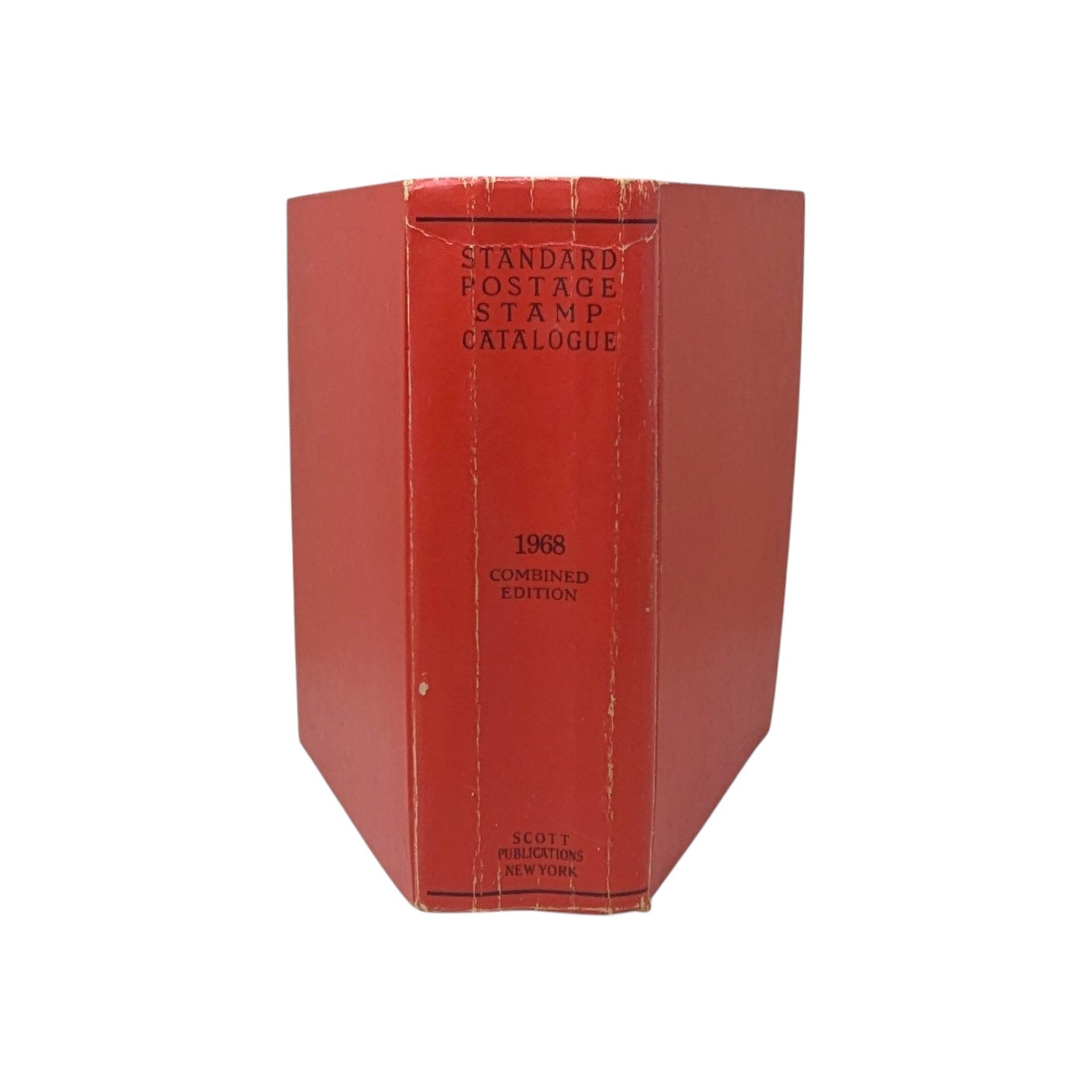 A thick, red hardcover book with a textured spine. The text reads Standard Postage Stamp Catalogue 1968 Combined Edition in black ink. The cover shows gentle edge wear and a slight lean from its substantial page count.