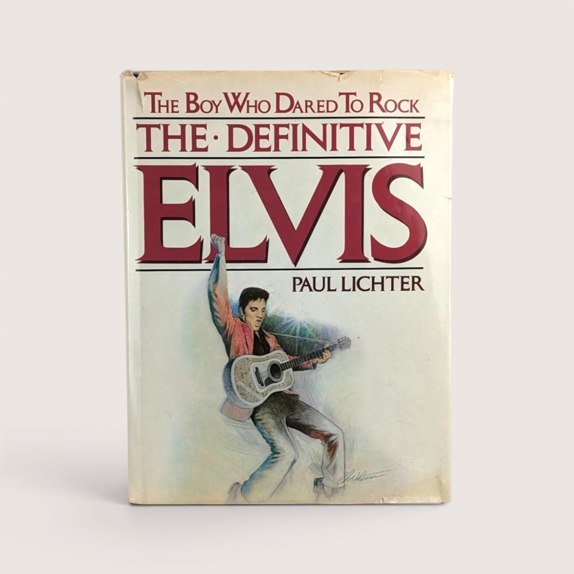 The front cover of the 1982 book titled The Definitive Elvis by Paul Lichter showing an illustration of Elvis Presley with a guitar.