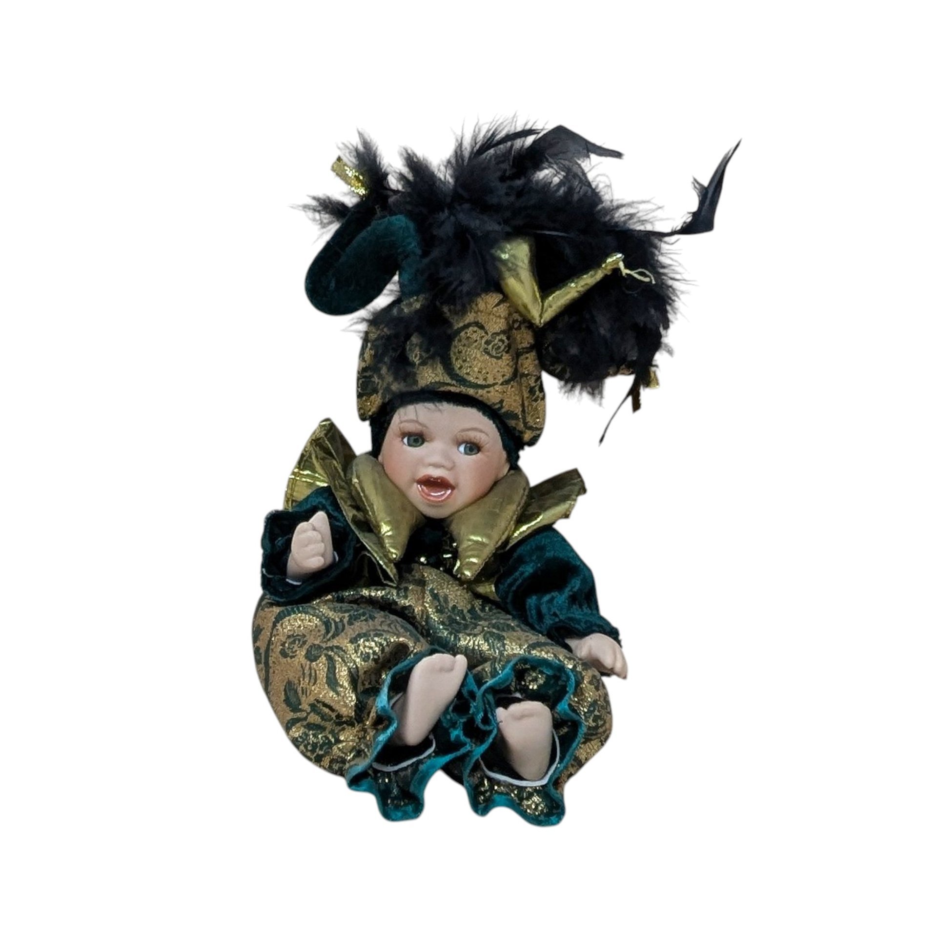 A 12-inch porcelain baby doll dressed as a jester in emerald green velvet and gold brocade, featuring a large feathered jester hat and gold metallic ruff.