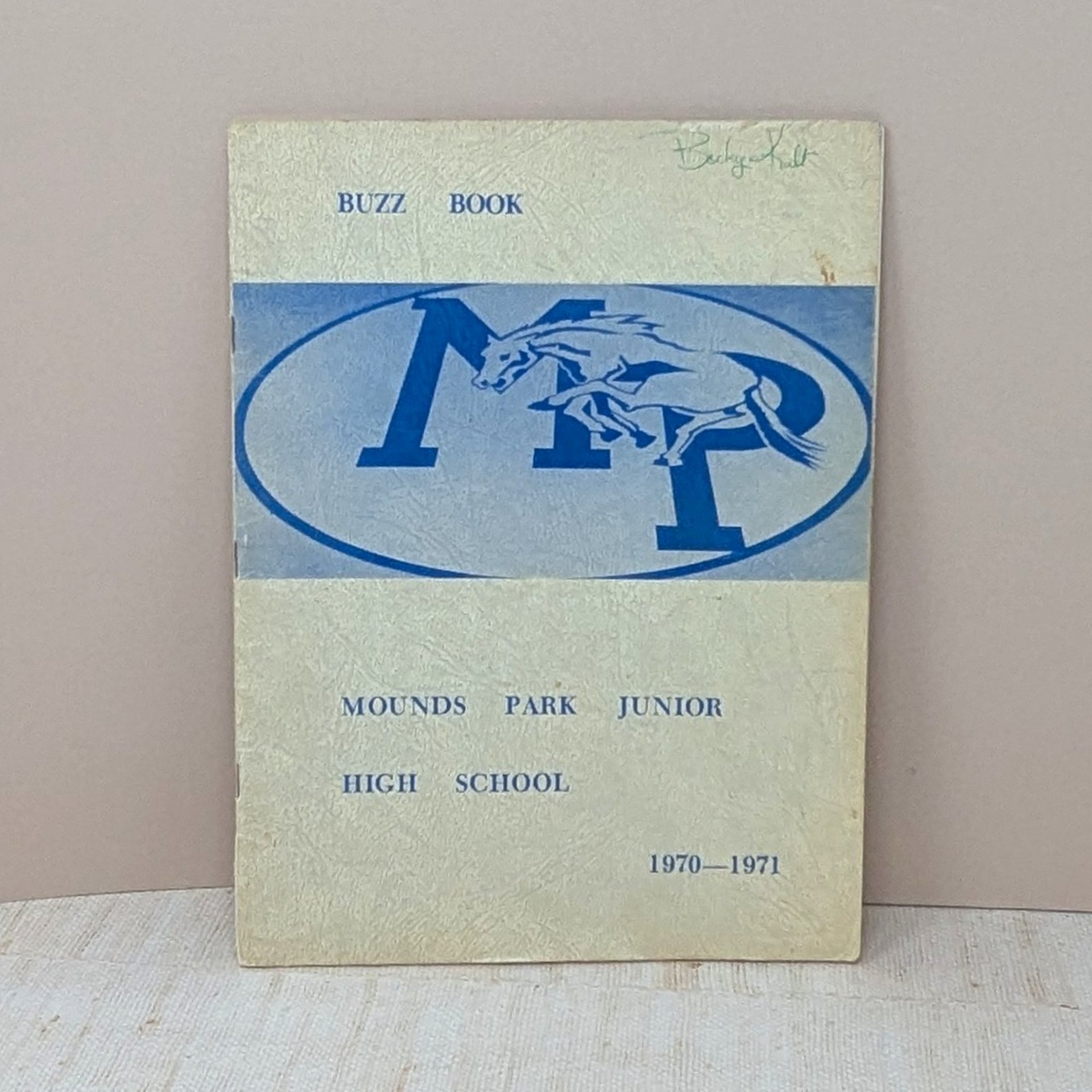A vintage 1970-1971 "Buzz Book" directory for Mounds Park Junior High, featuring a blue "MP" logo with a galloping mustang on a textured cream cover.