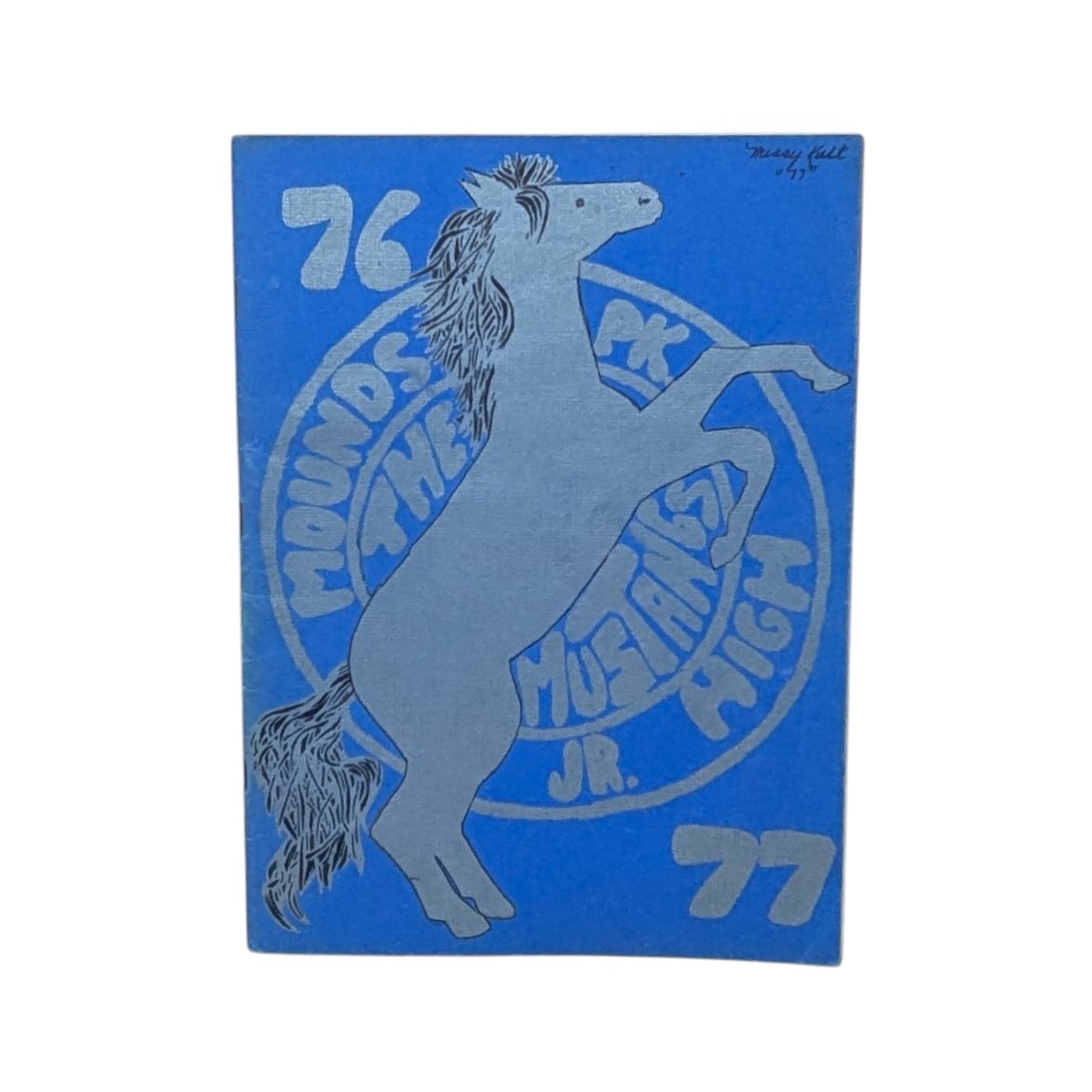 A vintage softcover yearbook with a bold blue cover. It features a large, silver-ink illustration of a rearing mustang horse centered over a circular school seal. The year 76-77 is printed in large block numbers.