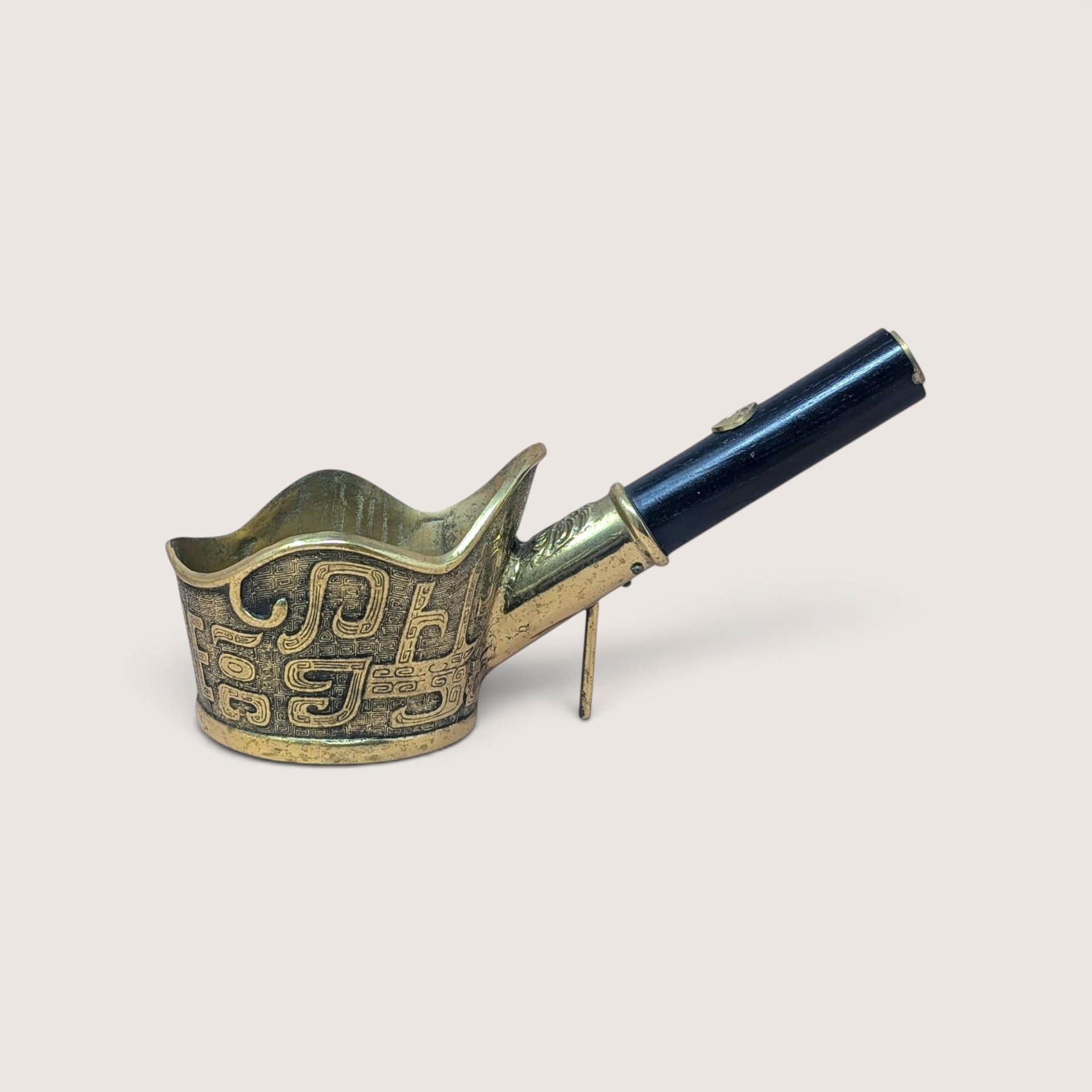 Vintage Chinese brass silk iron with black wood handle and geometric engraving.
