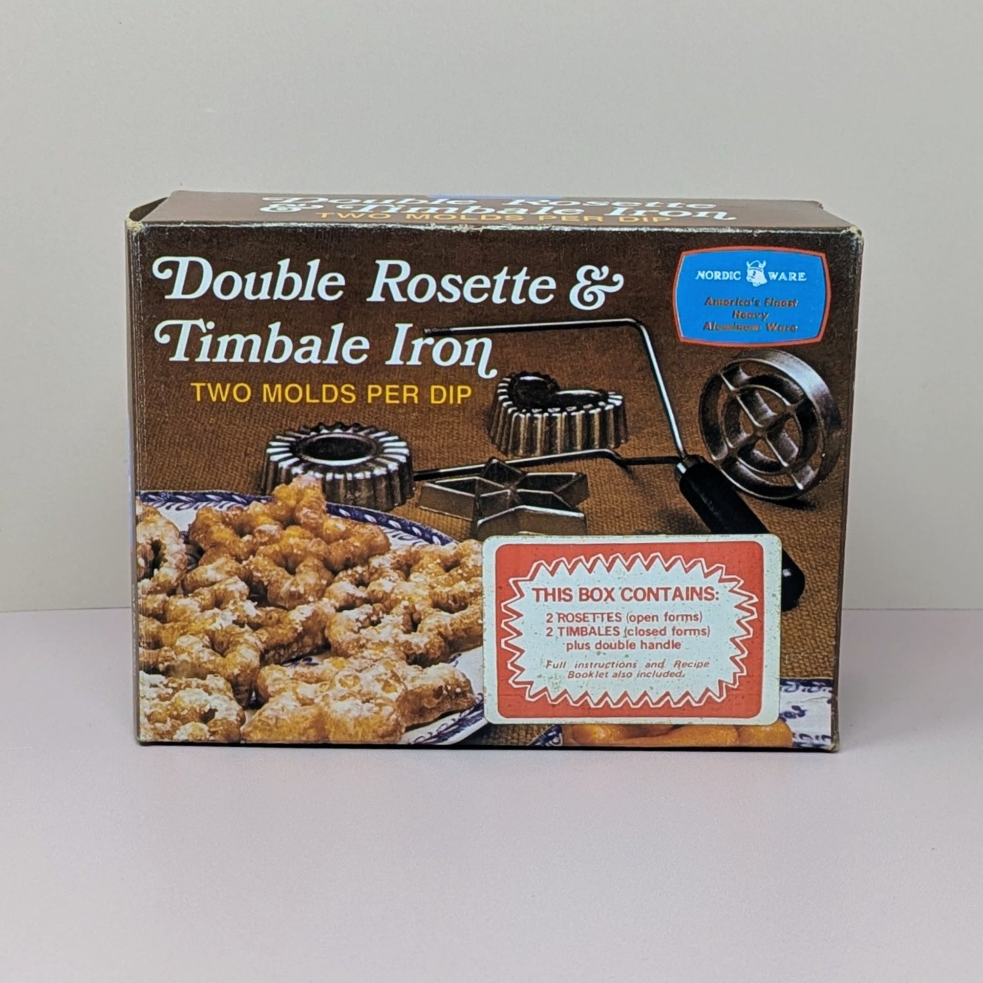 Original brown and red box for a Nordic Ware Double Rosette and Timbale Iron. The box features photos of golden fried pastries and the cast aluminum iron molds.