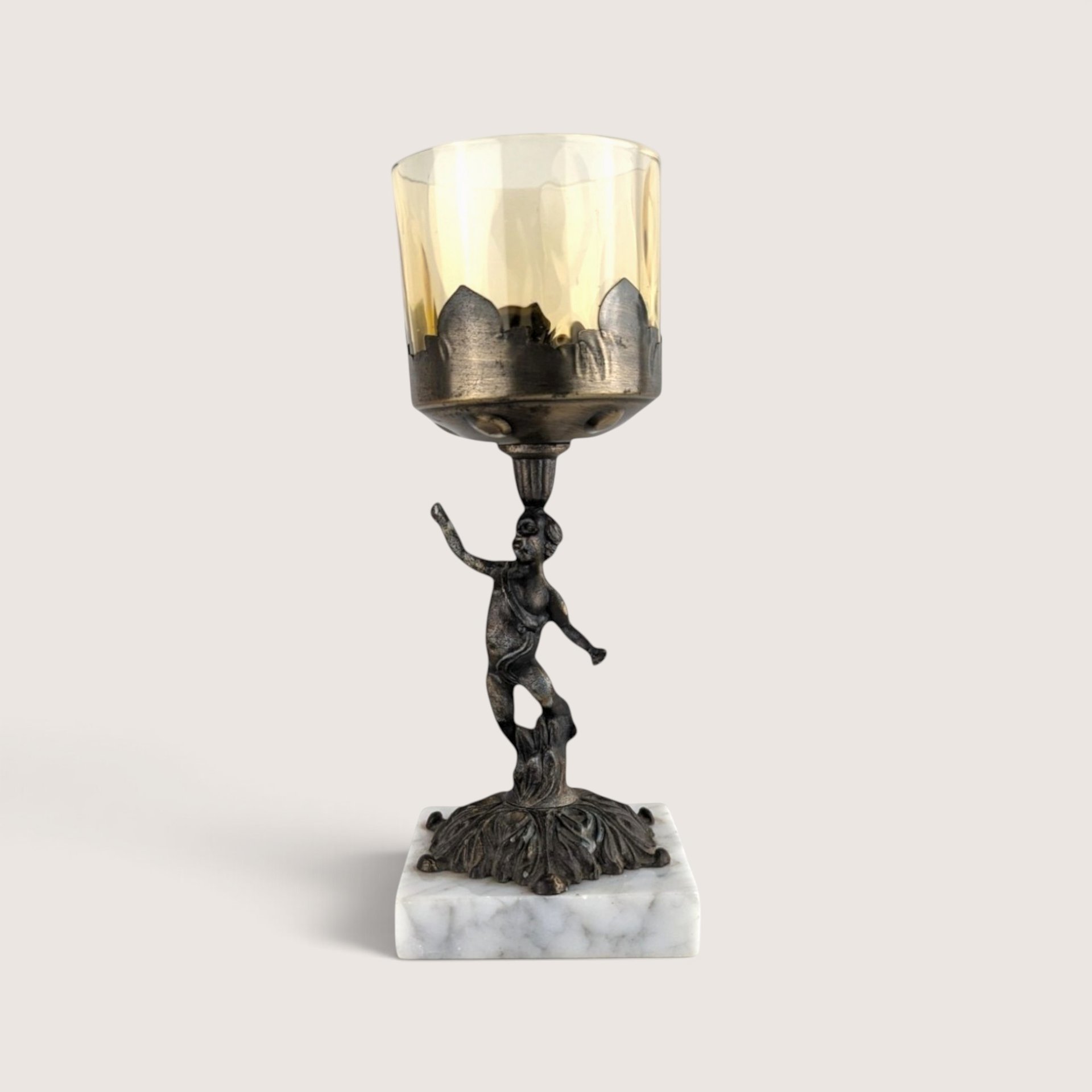 Vintage brass and marble cherub candle holder with amber glass votive cup.